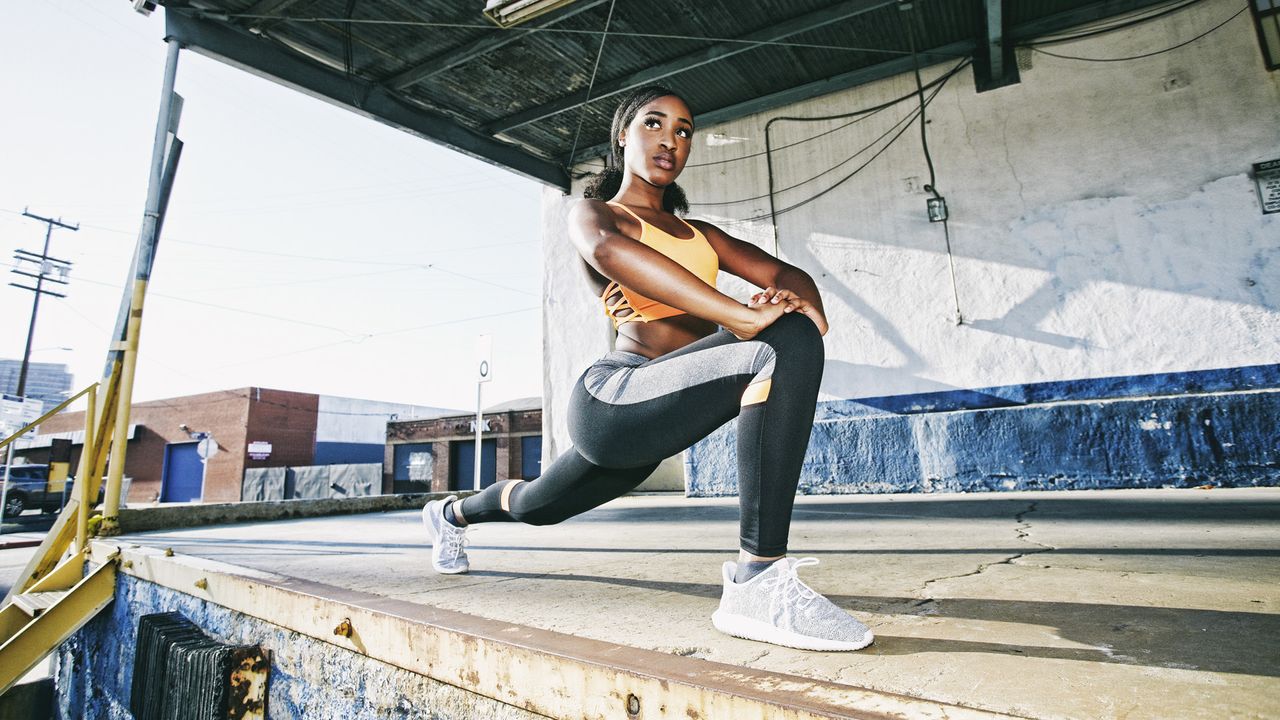 Beautiful young woman stretching legs on loading dock