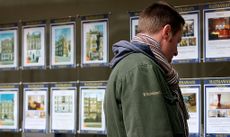 man looking at estate agent window