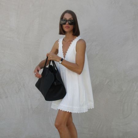 Woman wears white embroidered mini dress