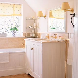 bathroom with pink wall white cabinets and wall lamps