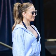 Jennifer Lopez wears a gray sweatshirt, dark heather gray leggings and white sneakers.