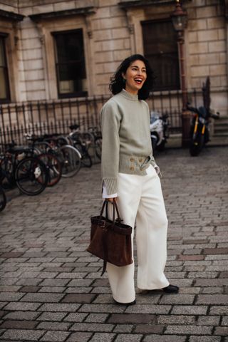 woman wearing sweater, pants, and tote bag