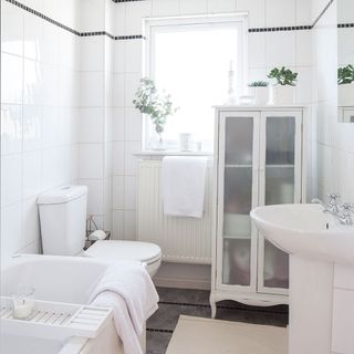 bathroom with white fixtures and radiator