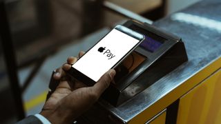 Close-up view of man using Apple Pay paying for public transport