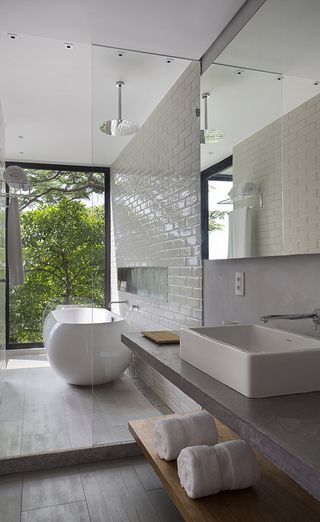 Bathroom with white wash basin bath tub and wooden bench