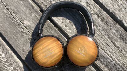 Audio-Technica ATH-WP900 headphones with wooden finish, featured with headphone DAC on surface