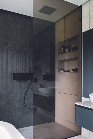 walk-in shower ideas recessed fittings in a black tiled shower