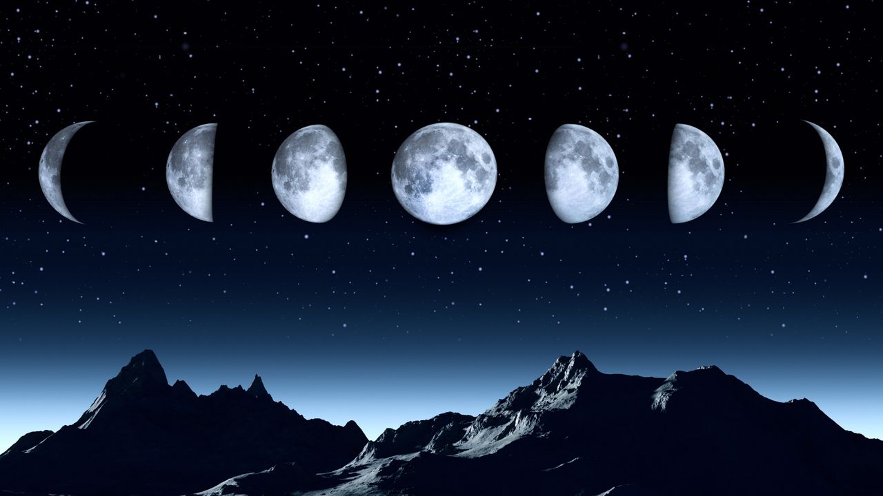 All phases of the moon on a clear dark sky - stock photo.