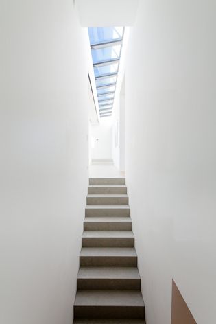 A narrow internal stairway with white walls