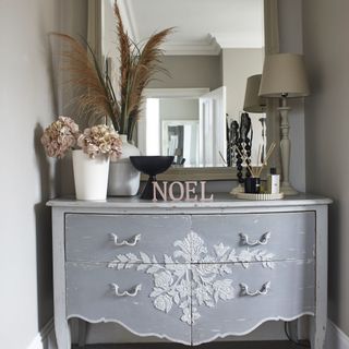 grey vanity unit with ornaments in front of mirror