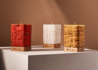 loro piana luxury candles in red, yellow, and white