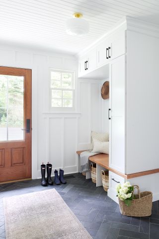 A mudroom in the entryway with soft furnishings