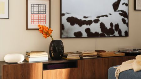 IKEA VARMBLIXT Smart Lamp styled atop of a wooden credenza alongside stacks of books and a sculptural vase