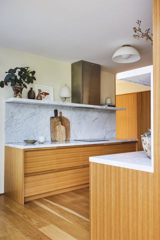 A kitchen with wooden cabinets and stone backsplash