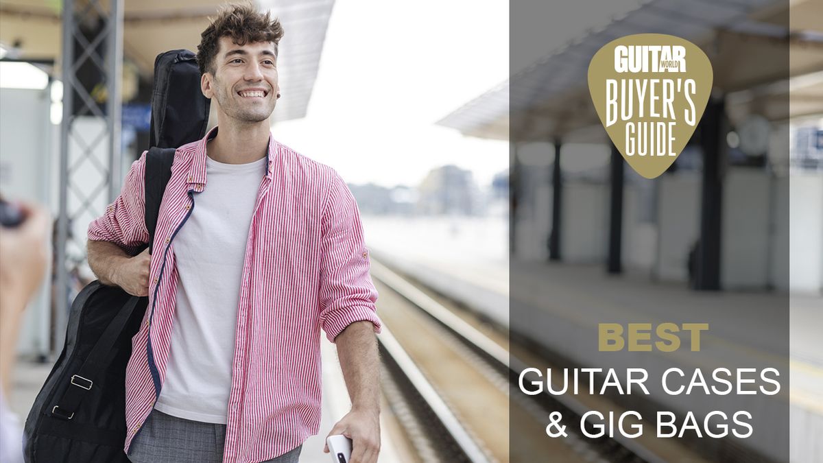 Man in pink shirt on train platform carrying a guitar in a case