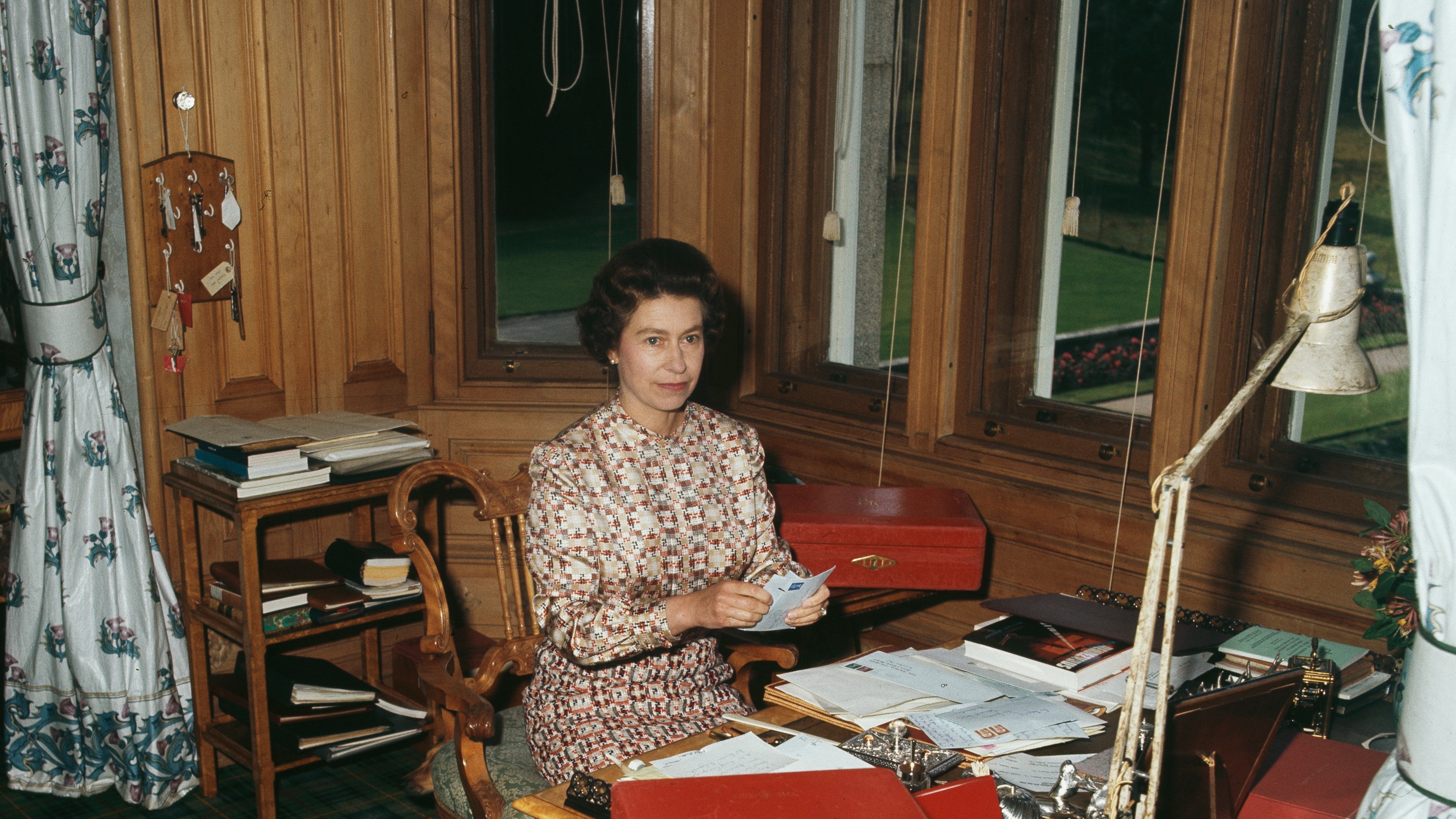 Queen Elizabeth sits at the writing desk in her study in Balmoral Castle, Aberdeenshire