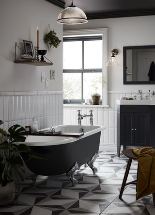 Black bathroom with painted black ceiling and black roll top bath