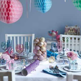 Dining table with pastel baubles and paper decorations