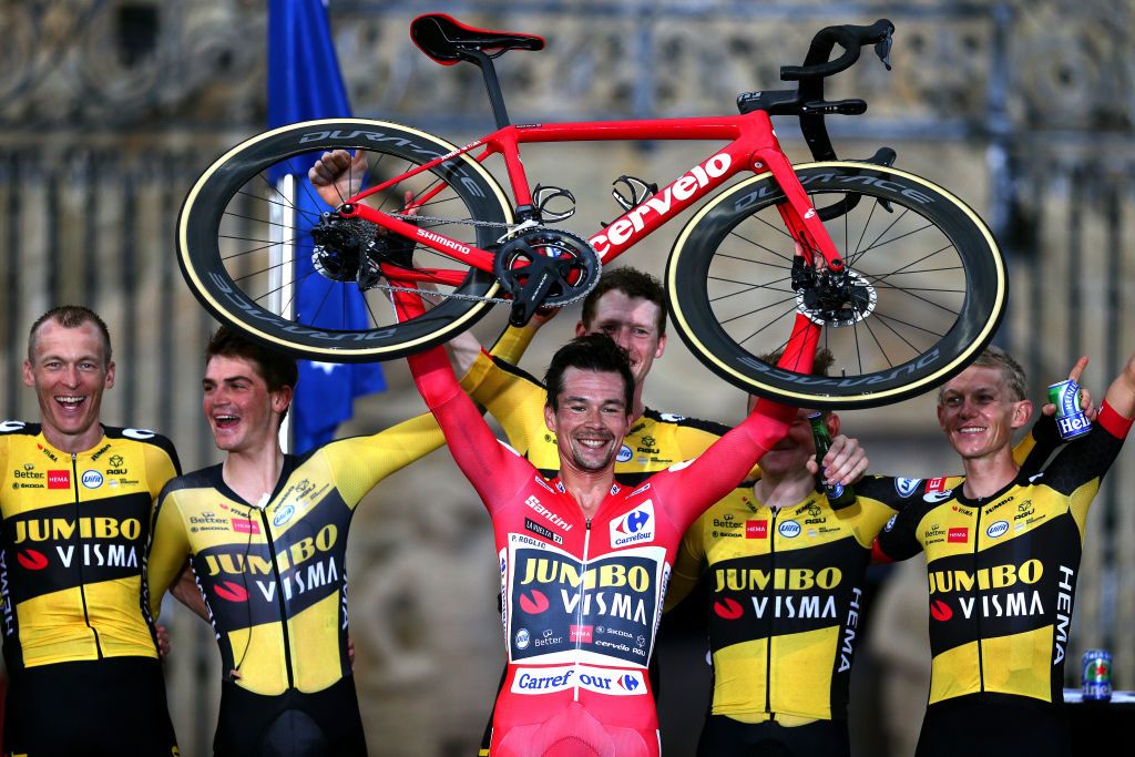 SANTIAGO DE COMPOSTELA SPAIN SEPTEMBER 05 LR Robert Gesink of Netherlands Sepp Kuss of United States Primoz Roglic of Slovenia red leader jersey Nathan Van Hooydonck of Belgium Sam Oomen of Netherlands and Koen Bouwman of Netherlands and Team Jumbo Visma celebrate winning on the podium ceremony while lifting his Cervelo bicycle after the 76th Tour of Spain 2021 Stage 21 a 338 km Individual Time Trial stage from Padrn to Santiago de Compostela lavuelta LaVuelta21 ITT on September 05 2021 in Santiago de Compostela Spain Photo by Gonzalo Arroyo MorenoGetty Images