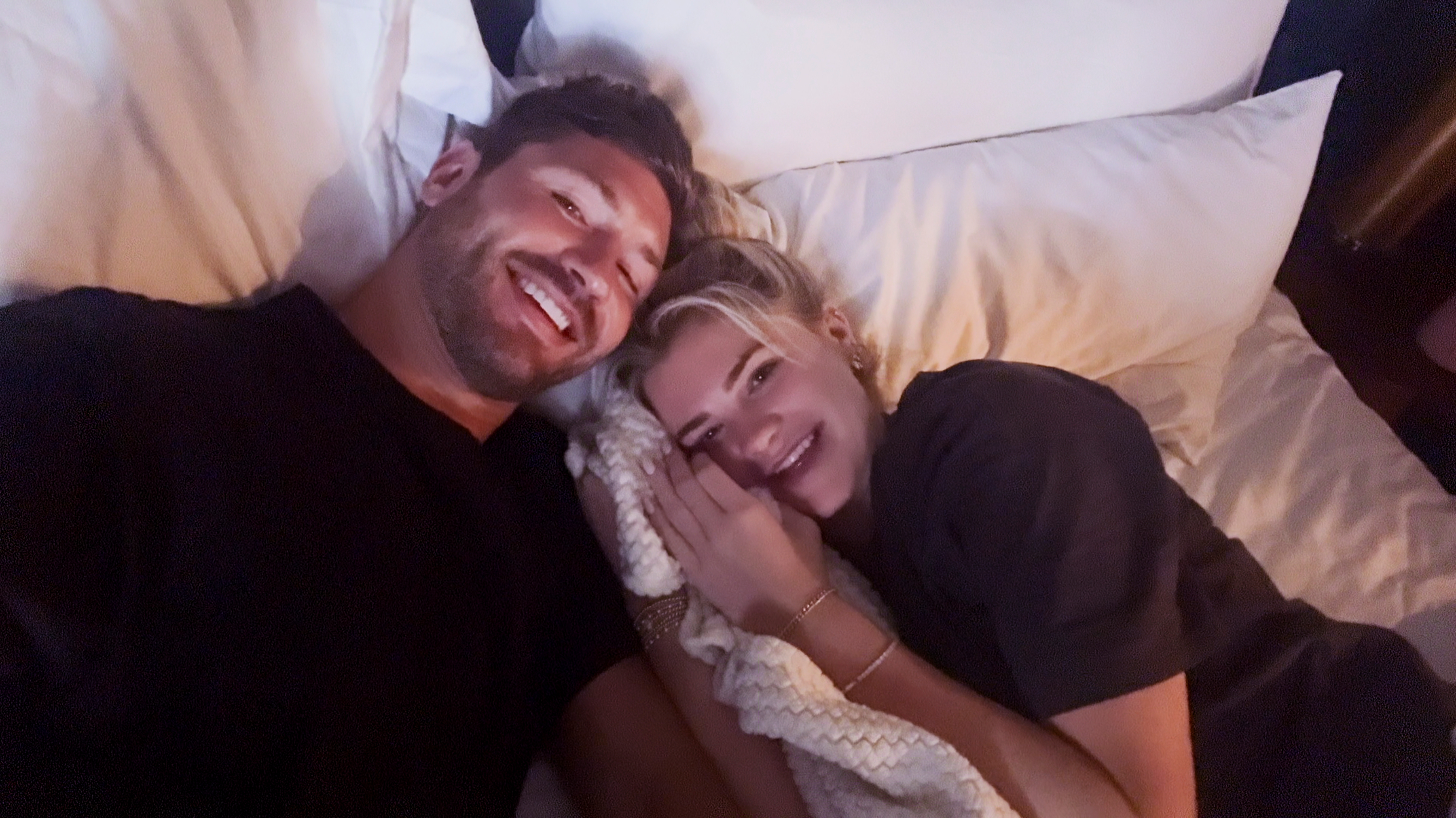 andrew Wheeler and Libby Vodicka take a selfie while smiling in bed together in age of attraction