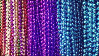 many plastic party beads in various colors, includng red, purple and blue.