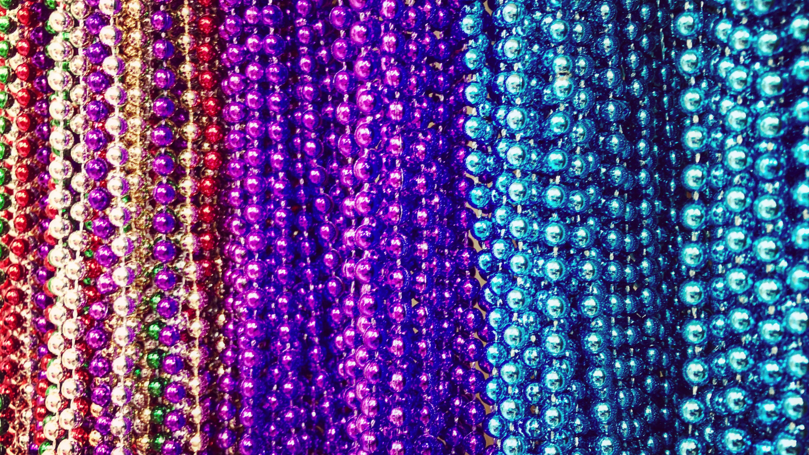 many plastic party beads in various colors, includng red, purple and blue.