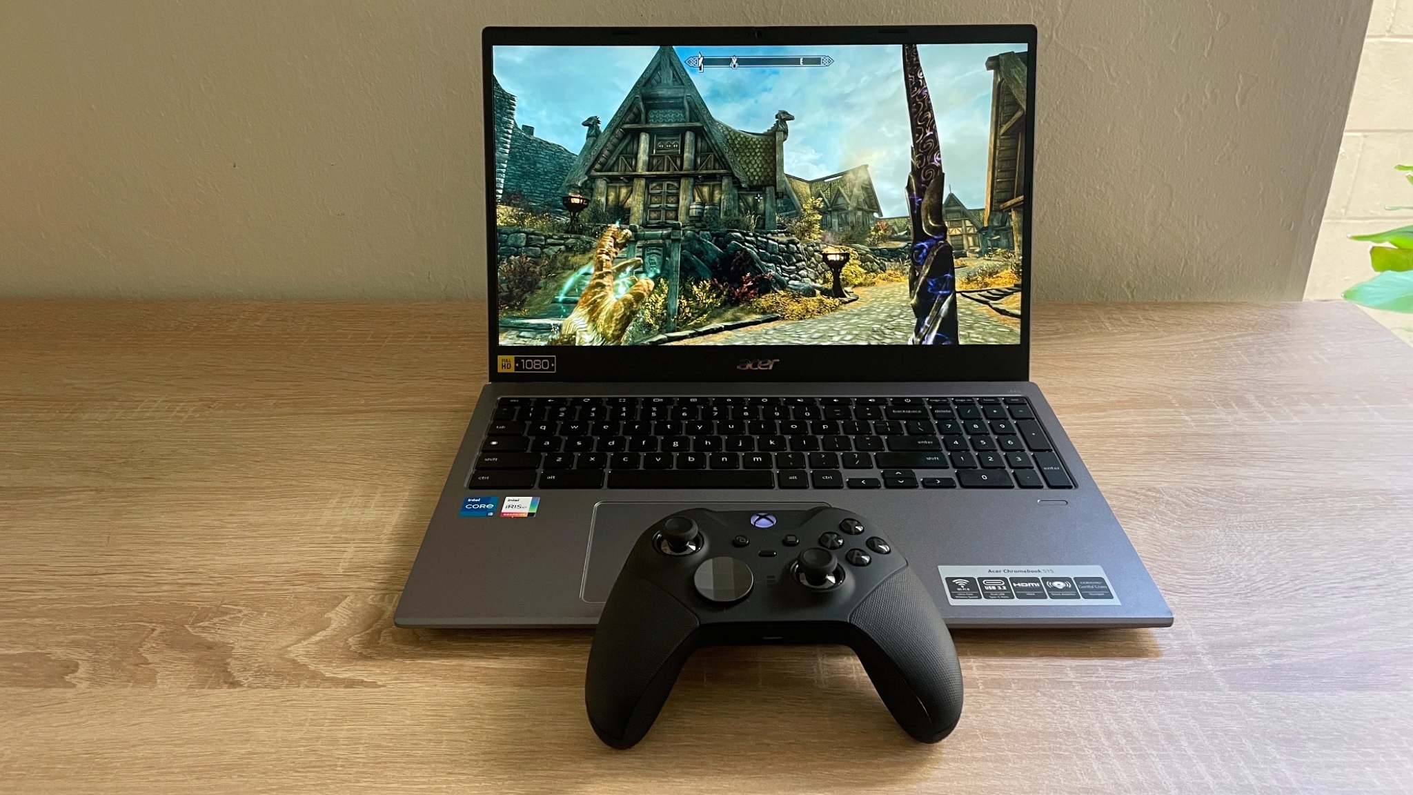 The Steam beta running on a Chromebook. The laptop is atop a wooden desk with a black Xbox controller sat on the front edge.