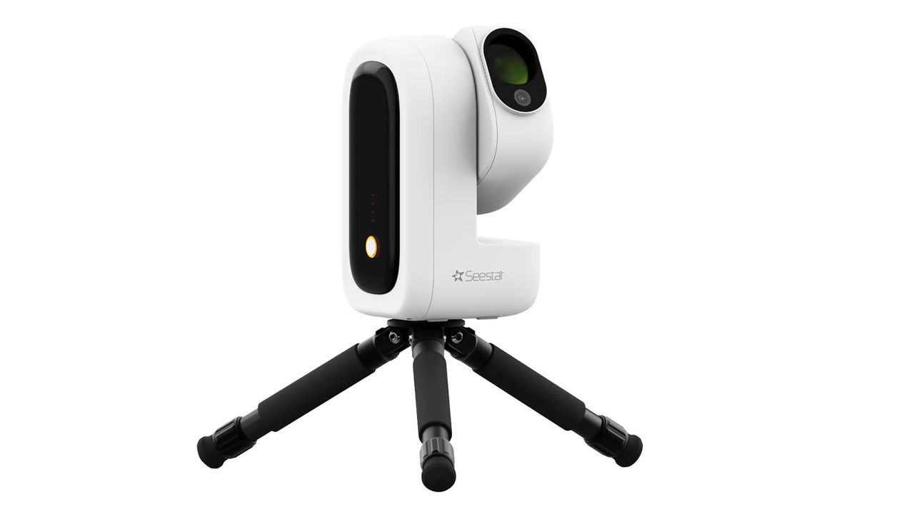 The ZWO Seestar S50 Pro smart telescope pointing upwards on a small black tripod, against a white background.