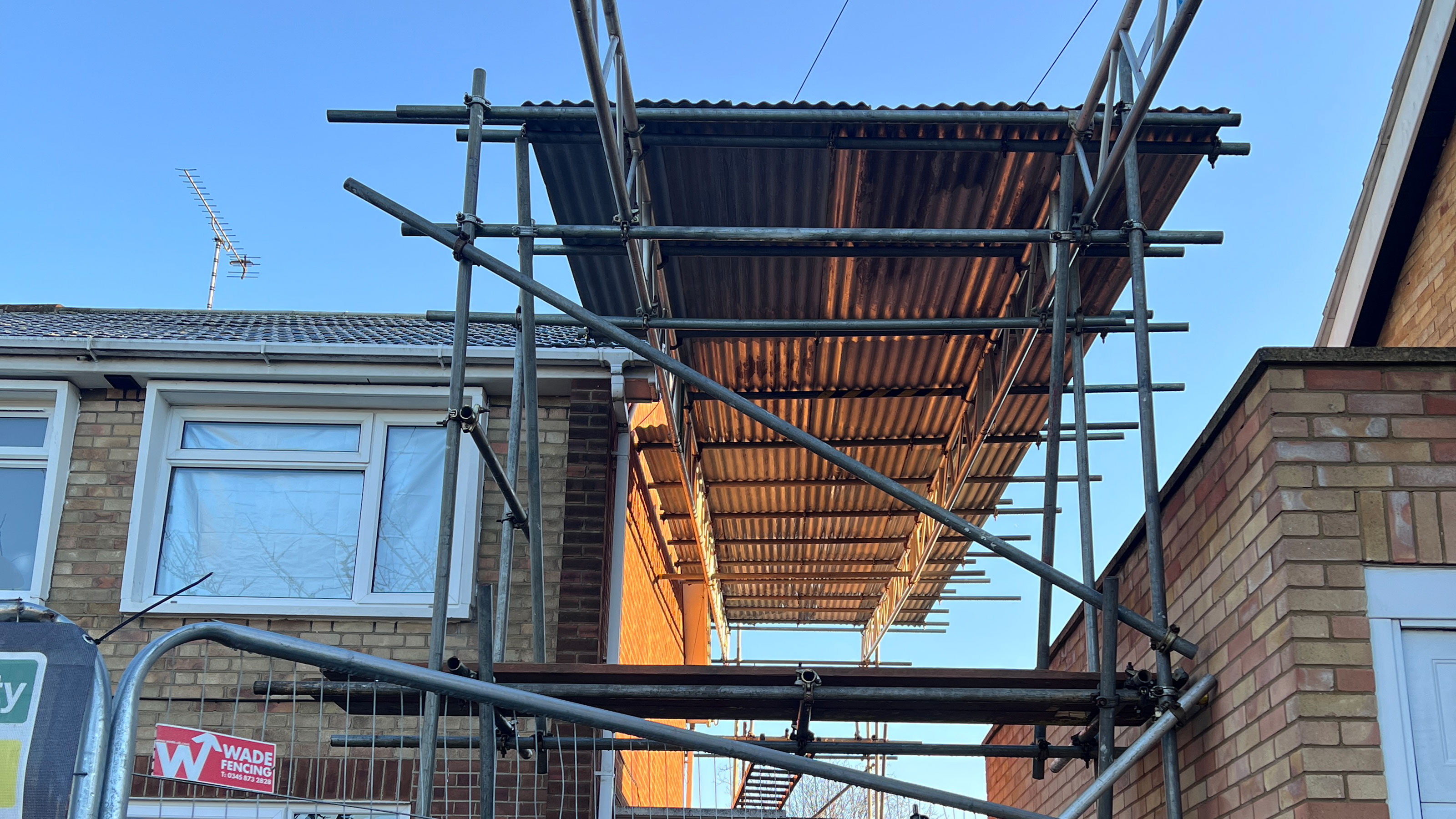 Temporary roof erected with scaffolding above home extension