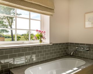 Bathroom with green tiled splashback in coastal Northumberland cottage