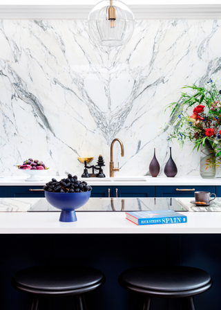 Bookmatched kitchen backsplash with dark blue cabinetry