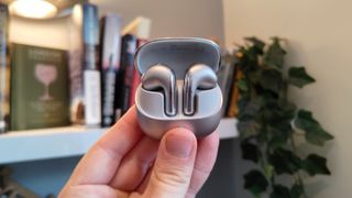 The Xiaomi Buds 5 on a bookshelf.