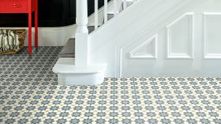 patterned luxury vinyl flooring in a hallway with white staircase