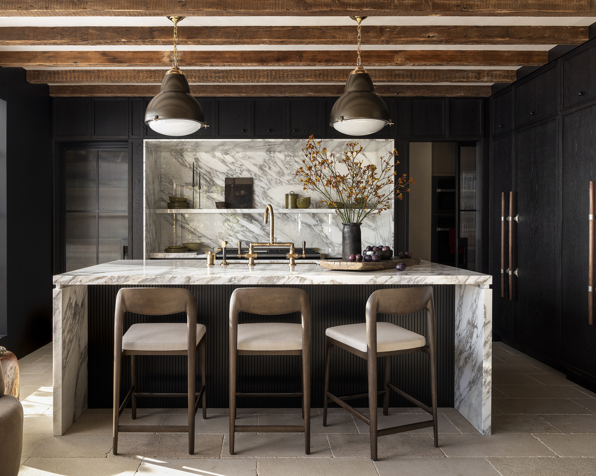 dark kitchen with white marble island and wood beams on the ceiling