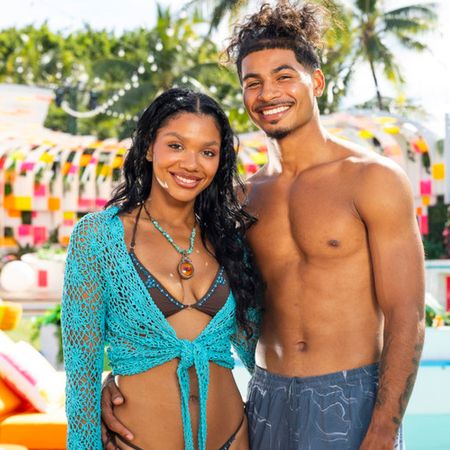 melanie wears a blue cover up and bikini and sincere wears swim trunks as they pose together by a pool in love island usa season 8