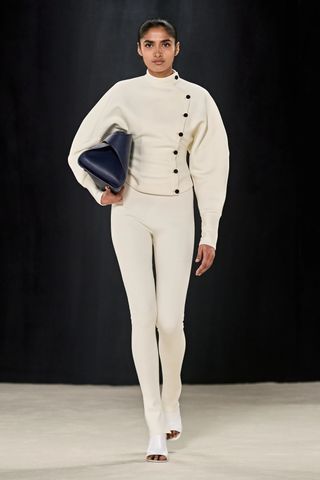 Model wears white leggings and jacket in Ferragamo fall winter 2023