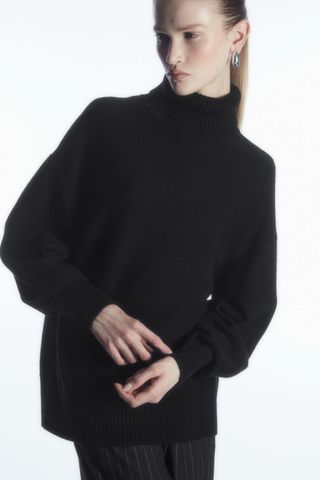 woman wearing black turtleneck jumper from the cos sale