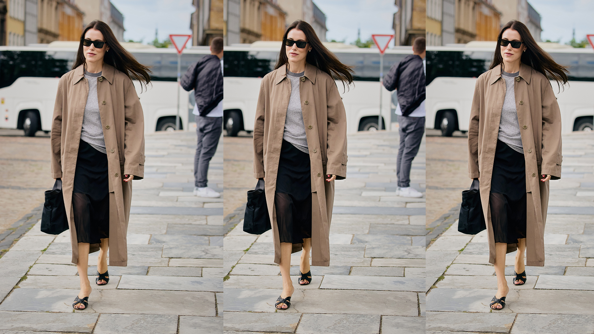 Woman wears trench coat black skirt, heels, and black handbag. 