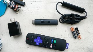 The Roku Streaming Stick 4K and its remote, power cord, adapter and batteries