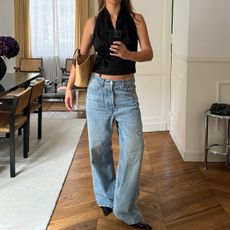 Woman taking a mirror selfie in baggy jeans