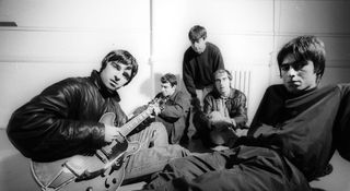 A black-and-white portrait of Manchester-based indie rock band Oasis in 1993, with Noel Gallagher playing a Gibson ES-335, and brother Liam to his right; the band reformed in 2024, announcing a string of 2025 dates.