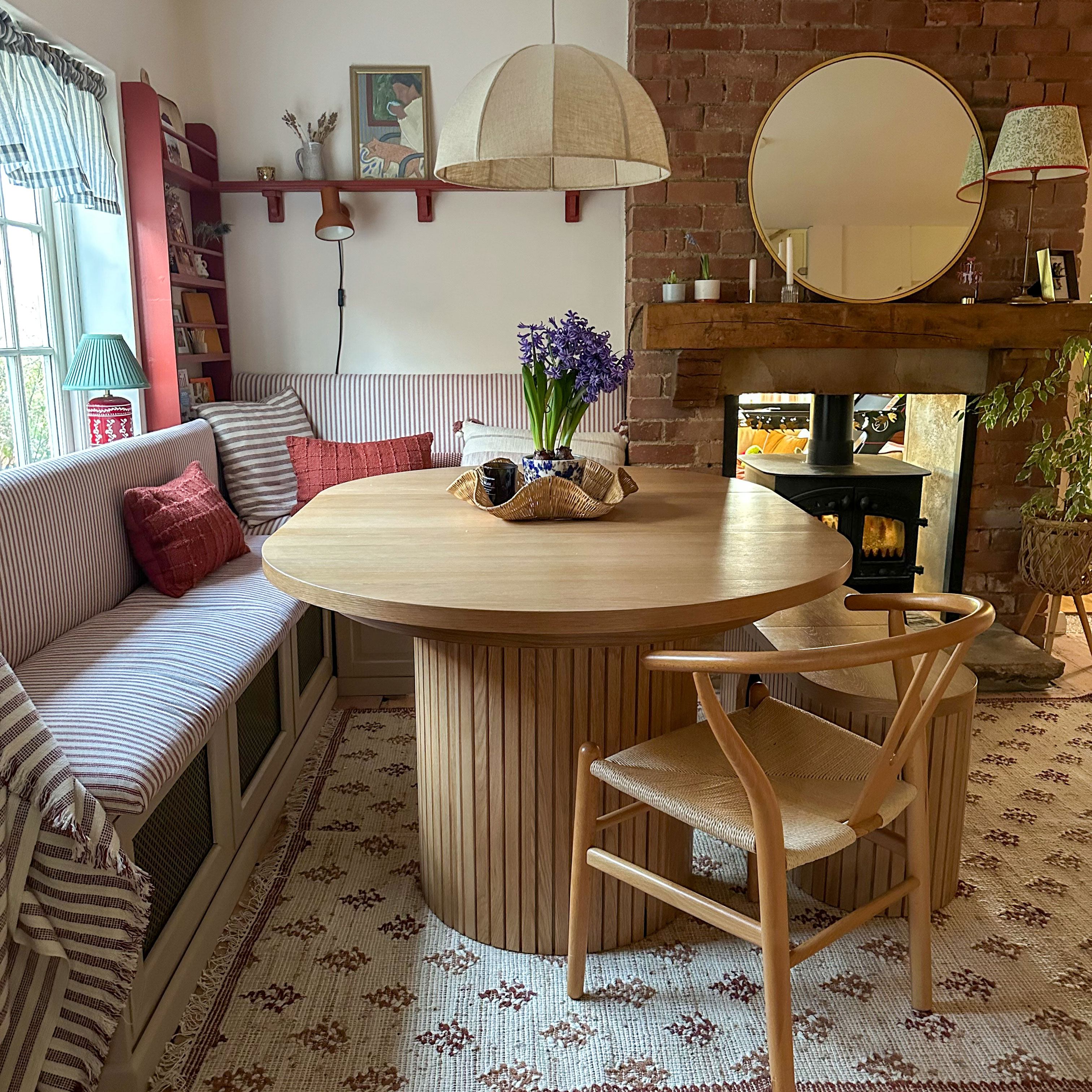 Kitchen area showing striped upholstered corner banquette around wooden table