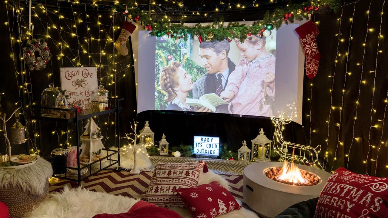 outdoor movie theater with fairy lights, cushions and projector screen 