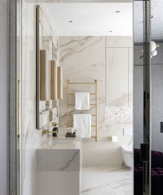 Marble bathroom with gilded faucets and shower rack