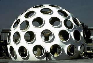 Archival image of the creator himself, Buckminster Fuller, in front of the Fly's Eye dome in 1980.