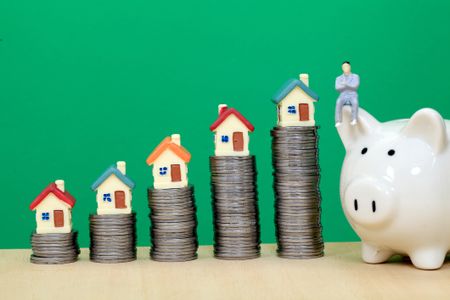 Model houses on piles of coins