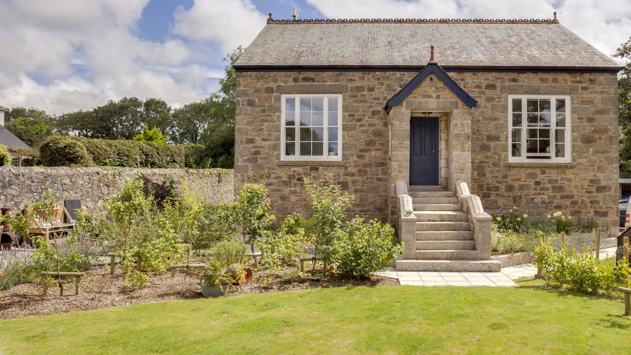 exterior of renovated schoolroom with steps and grass garden