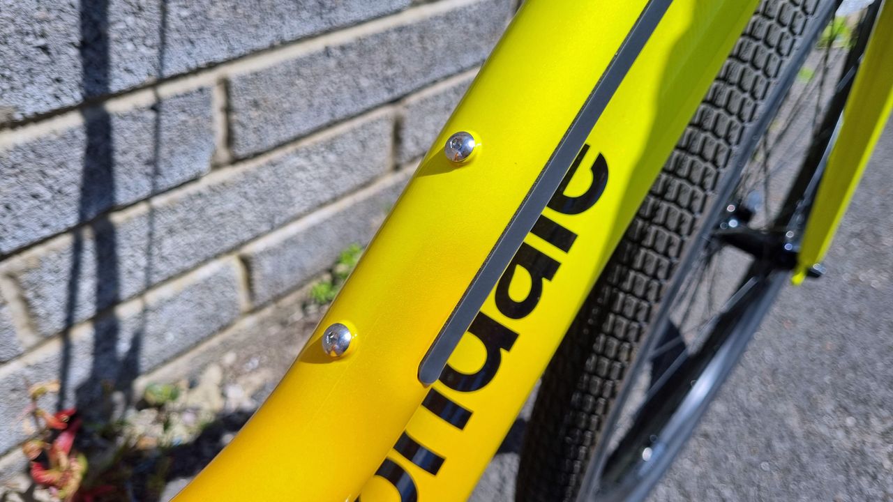 A close up of two bottle cage mounts on a sloped yellow top tube
