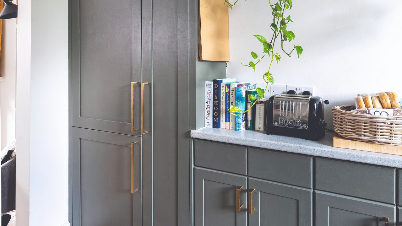 Grey-coloured kitchen with brass hardware fittings