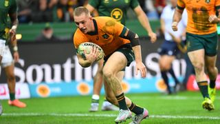 Australia's scrum-half Tane Edmed dives across the line to score a try during the Rugby Championship second round Test match between South Africa and Australia at the DHL Stadium in Cape Town on August 23, 2025. 